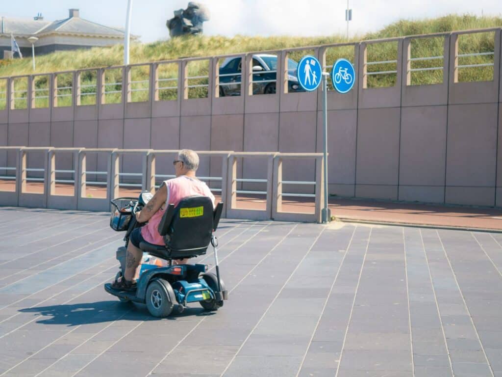 אדם מבוגר נוסע בקלנועית בטיילת